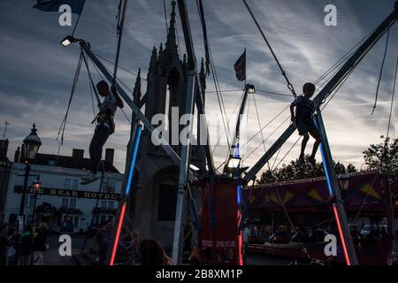 Ein Bungee-Trampolin, das in der Abenddämmerung auf einer Messe verwendet wird, Devizes Market Place, Wiltshire August 2016 Stockfoto