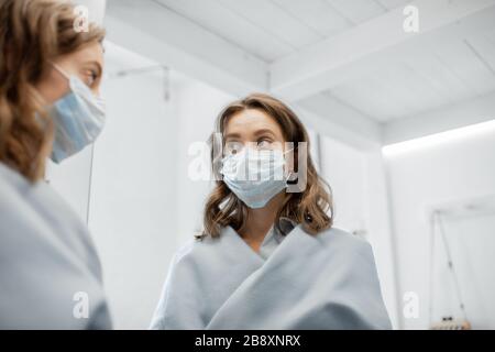Frau, die im Freien eine medizinische Maske trägt und während einer Epidemie vor dem Virus schützt. Konzept der Bettluftverschmutzung oder Virus-Pandemie Stockfoto