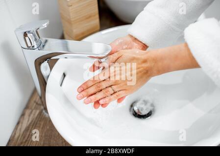 Frau wäscht die Hände im Badezimmer, Nahaufnahme der Hände Stockfoto