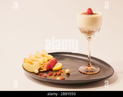 Gesundes und farbenfrohes Frühstück mit frischem Obst, Trockenobst und Sojajoghurt mit Müsli Stockfoto