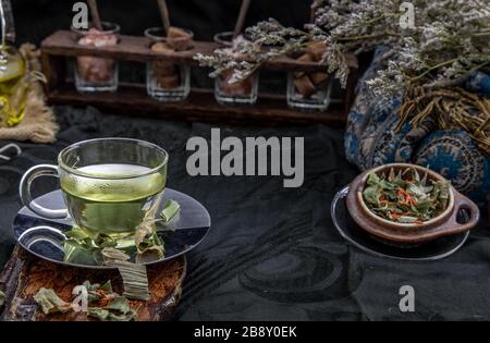 Eine Tasse Pandanblatt-Tee, indische Marschen Flabane Pflanzen Blätter mit Safflower getrocknet (Saffron-Ersatz) auf dunklem Hintergrund. Thailändische Kräuterpflanze und -Alt Stockfoto