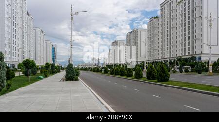 Asjchabad, Turkmenistan - 1. Juni 2019: Die weiß-marmorne Stadt Asjchabad mit großen Gebäuden und Wahrzeichen und leeren Straßen in Turkmenistan. Stockfoto