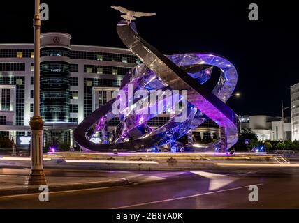 Asjchabad, Turkmenistan - 1. Juni 2019: Die weiße und marmorne Stadt Asjchabad mit großen Gebäuden, Statue in der Nacht in Turkmenistan. Stockfoto