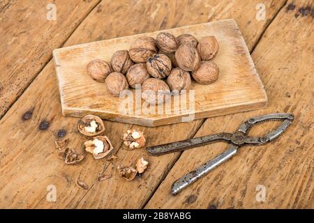 Walnüsse und Nussknacker auf einem alten Holztisch im Landhausstil - selektiver Fokus Stockfoto