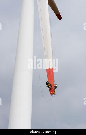 Reparaturarbeiten an den Rotorblättern einer Windmühle zur Stromproduktion - Kopierraum Stockfoto