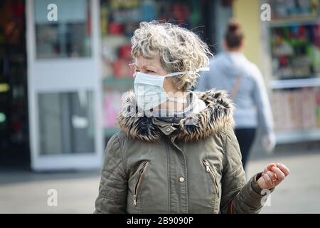 Eine ältere Frau, die auf dem Markt eine Maske trägt. Selektiver Fokus auf das Gesicht. Mailand, Italien - März 2020 Stockfoto