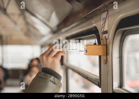 Markieren des Tickets in der Straßenbahn mit einem Perforator Stockfoto