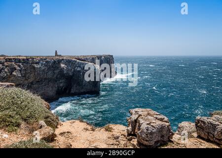 Abgeschiedener Leuchtturm auf einer Klippe an der Atlantikküste der Algarve, Portugal, bei sonnigem Wetter. Lizenzfreies Foto. Stockfoto