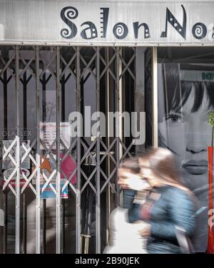 23. März 2020, Hessen, Frankfurt am Main: Zwei junge Frauen gehen an einem geschlossenen Friseursalon im Frankfurter Nordende vorbei. Um die Ausbreitung des Coronavirus zu verlangsamen, haben Friseure nun geschlossen. Foto: Frank Rumpenhorst / dpa Stockfoto