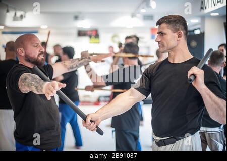 Eine große Gruppe von Studenten übt auf dem Kapap Martial-Arts-Seminar Techniken für den kampf mit dem philippinischen Escrima arnis Stick Stockfoto