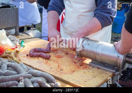 Herstellung hausgemachter Würstchen in Naturdarm. Füllung der Füllung mit hausgemachter Wurst. Stockfoto