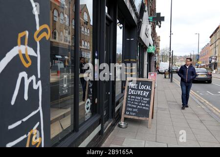 London/Großbritannien - 20. März 2020: Ein Mann läuft am Flaschen-Apostel-Off-License in Crouch End, North London, vorbei, das eine kostenlose Lieferung inmitten der Coronavirus-Pandemie anbietet Stockfoto