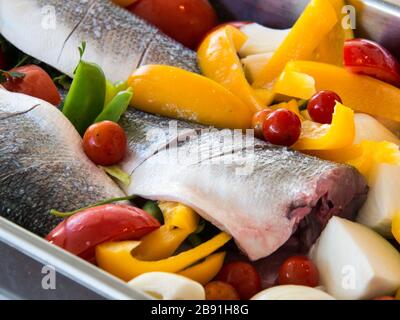 Seebarsch, Paprika, Tomate und Zwiebel bereit zum Backen Stockfoto
