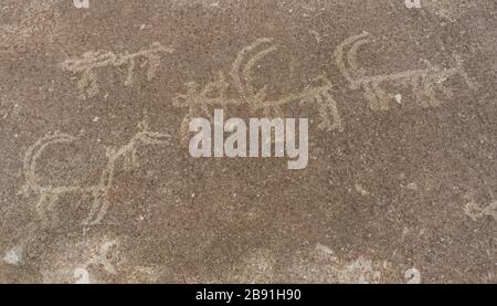 Alte Petroglyphen von Jägern und Ibex bei Langar auf Felsen und Berg im Wakhan-Korridor in Tadschikistan. Stockfoto