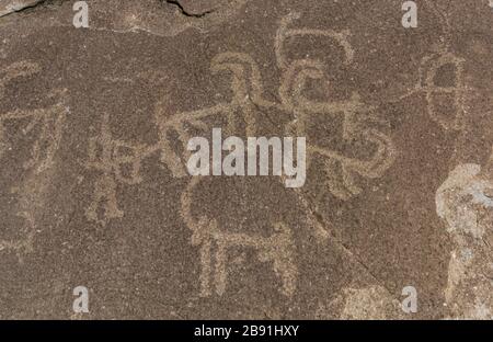 Alte Petroglyphen von Jägern und Ibex bei Langar auf Felsen und Berg im Wakhan-Korridor in Tadschikistan. Stockfoto