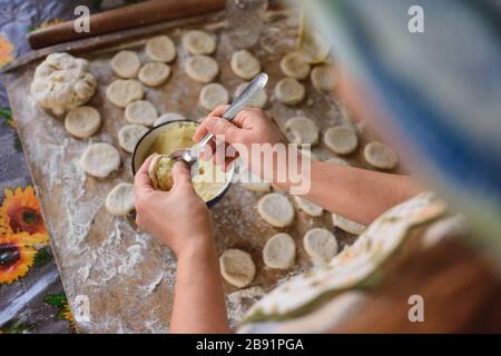 Ein mageres ukrainisches Gericht, eine Frau in der Küche bereitet Knödel mit Kartoffeln vor.2020 Stockfoto