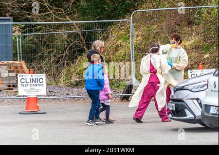 Dunmanway, West Cork, Irland. März 2020. Das Dunmanway Community Hospital betreibt derzeit ein Coronavirus-Notfalltestzentrum. Eine Familie bereitet sich darauf vor, das COVID-19 Testzentrum zu betreten, während zwei Krankenhausmitarbeiter darauf schauen. Quelle: AG News/Alamy Live News Stockfoto