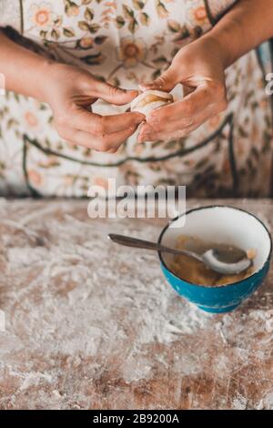 Frau übergibt Knödel mit Kartoffeln auf weißem Hintergrund, traditionelle ukrainische Küche.2020 Stockfoto