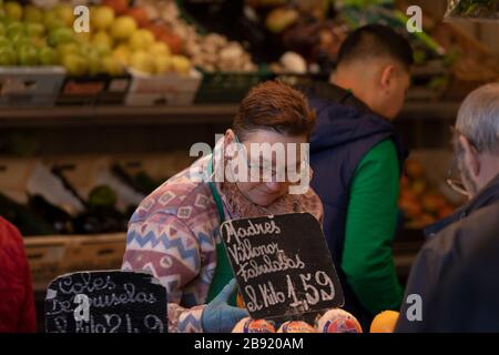 Zaragoza, Spanien - 6. Februar 2020: Eine Frau, die als Ladenbesitzerin in einem Lebensmittelhändler arbeitet, bereitet einen Auftrag für einen Kunden auf dem Markt in Lanuza, Zaragoza, vor. Stockfoto