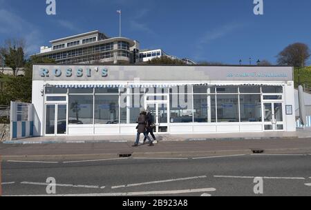 Zwei Damen laufen an Rossis Eisdiele an der Küste von Southend in Essex vorbei, wie Premierminister Boris Johnson sagte, die Regierung sei bereit, härtere Beschränkungen zu verhängen, um die Ausbreitung des Coronavirus einzudämmen, wenn die Menschen nicht den Leitlinien für soziale Distanzierungen folgen. Stockfoto