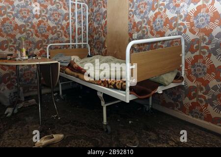Athen, Griechenland - 16. April 2019: Verlassene Raumausstattung mit unfertigen antiken Krankenhausbetten und schmutzigem Teppich. Stockfoto