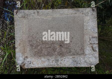 Verwittertes, leeres Holzschild am rostigen Zaun. Hintergrunddesignelement mit Kopierbereich. Stockfoto