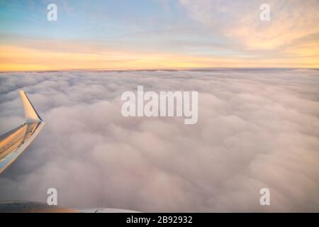 Blick vom Flugzeug bei Sonnenaufgang über den Wolken in Valencia Stockfoto