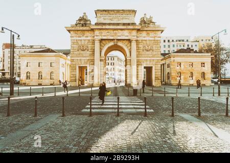 Dame überquert die Straße und telefoniert am tor porta Garibaldi Stockfoto