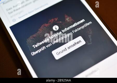 Smartphone mit aufgedeckten Fehlinformationen in einem sozialen Netzwerk, Smartphone mit aufdecktem Falschinformation im eigenen sozialen Netzwerk Stockfoto