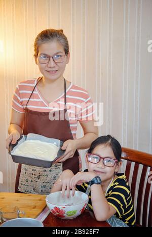 Mutter und Tochter mit Kuchen im Backblech Stockfoto