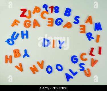 Verschiedene farbige Buchstabenblöcke, die über einen isolierten weißen Hintergrund verstreut sind Stockfoto