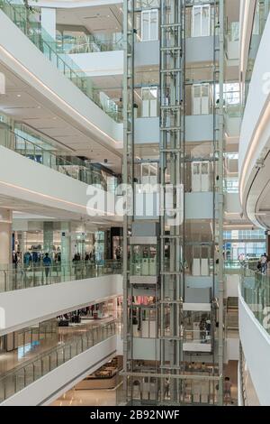SHANGHAI, CHINA - 10. NOVEMBER 2018. Panorama-Aufzüge im Atrium einer neuen Shopping Mall LuOne Shanghai. Glasaufzüge in White Retail Interior des Stockfoto