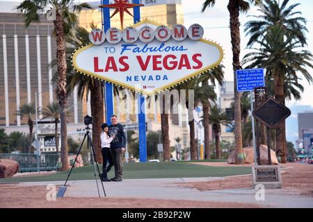 Las Vegas, Nevada, USA. März 2020. Die Einwohner von Las Vegas, Sharon (L) und Chris Justice, nutzen das menschenleere Willkommensschild in Las Vegas, um am 23. März 2020 in Las Vegas, Nevada, ein Foto von sich zu machen. Nevada Reg. Steve Sisolak ordnete an, bis zum 16. April unwesentliche Geschäfte im Staat zu schließen, um die Verbreitung des Virus zu bekämpfen. Die Weltgesundheitsorganisation erklärte das Coronavirus (COVID-19) am 11. März zu einer globalen Pandemie. Credit: David Becker/ZUMA Wire/Alamy Live News Stockfoto