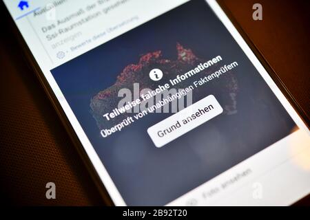 Smartphone mit aufgedeckten Fehlinformationen in einem sozialen Netzwerk, Smartphone mit aufdecktem Falschinformation im eigenen sozialen Netzwerk Stockfoto