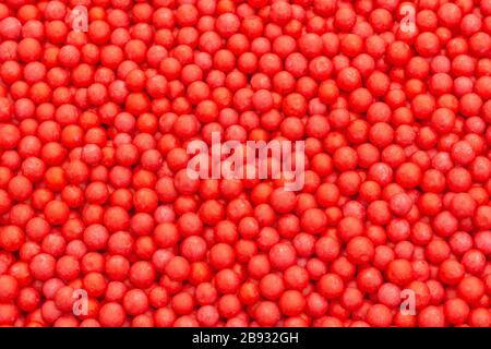 Farbige kleine rote Polystyrolkugeln. Konzept für Covid-19 Selbstisolation, Krankheitsträger, infizierte Person, isoliert, in der Menge verloren, abstrakt. Stockfoto