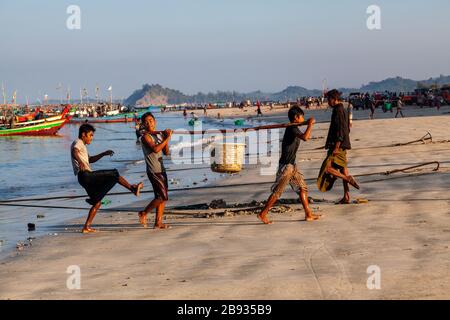 Der morgendliche Fang ist im Fischerdorf Ngapali angekommen. Der Fisch wird an Land gebracht und geteilt oder verkauft. Ngapali, Rakhine-Staat, Myanmar. Stockfoto