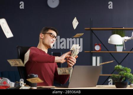 Ich bin reich. Portrait eines jungen Freiberuflers oder Geschäftsmannes im Hom Stockfoto