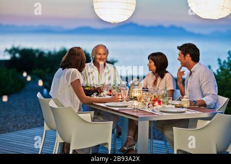 Freunde genießen Sie ein Abendessen im Freien auf der Veranda. Stockfoto