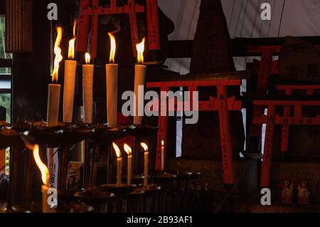 Ein Bild von kleinen Torii-Toren und Kerzen am Fushimi Inari Taisha-Schrein. Stockfoto