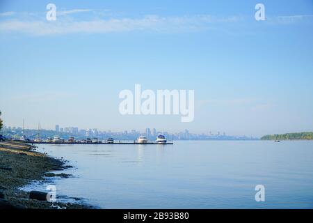 Blick auf den großen Fluss, über den man mit Booten und der Stadt den Pier sehen kann. Stockfoto