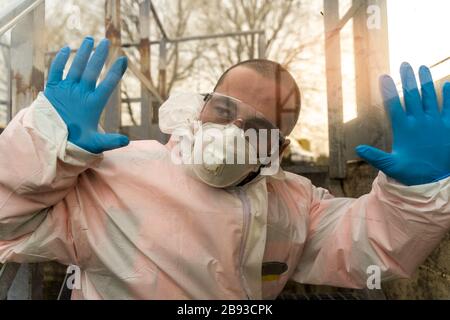 Müde Anti-Virologe-Krankenschwester bei der Pause entspannt sich während des Coronavirus-Notfalls an ein Fenster gelehnt Stockfoto