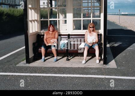 AJAXNETPHOTO. WORTHING, WEST SUSSEX, ENGLAND. - MENSCHEN, DIE DIE SONNE IN EINEM VON MEHREREN UNTERKÜNFTEN ENTLANG DER STRANDPROMENADE GENIESSEN.FOTO: JONATHAN EASTLAND/AJAX REF:CD0222 21 18A Stockfoto