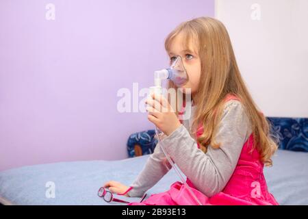 Kinder mit asthmatischen Problemen nehmen Einatmen mit Maske im Gesicht, Haustherapie. Stockfoto