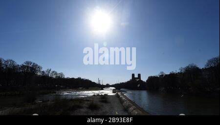 München, Deutschland. März 2020. Bei starker Sonneneinstrahlung und kalten Temperaturen ist ein Spaziergang entlang der Isar ein guter Weg, sich zu entspannen, wenn man nach Süden zur Kirche St. Maximilian und zur Heizungsanlage blickt. Kredit: Felix Hörhager / dpa / Alamy Live News Stockfoto