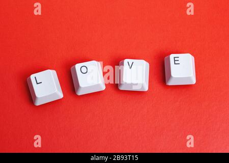Wortliebe aus Tastaturtasten auf rotem Hintergrund Stockfoto