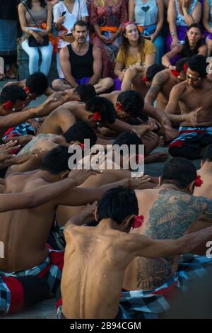 Eine Gruppe von männlichen Darstellern, die sauber in schwarz-weiße karierte Kleidungsstücke im Uluwatu-Tempel eingewickelt sind. Stockfoto