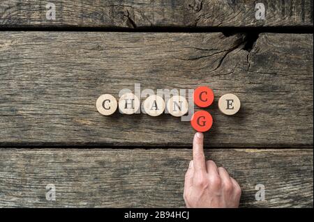 "Word Chance" hat auf Holzkreisen mit männlichem Handpusher in Buchstabe G geschrieben, um ihn in Veränderung zu ändern. Stockfoto