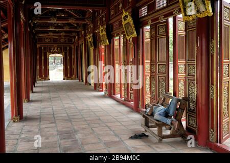 Mann, der auf einer Bank in der Kaiserstadt Hue, Vietnam, ein Nickerchen macht Stockfoto