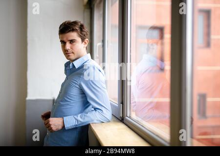 Nachdenklich Geschäftsmann Kaffee trinken, durch das Fenster an der grossen modernen Stadt suchen, in Pause, tief in Gedanken versunken, genießen, warten auf Konferenz Stockfoto