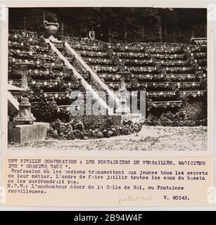 Foto-Propaganda: Der Brunnen der Versailler Agence LAPI (Les Actualités Photographiques Internationales). "Photographie propagande: Les fontainiers de Versailles". UNE VIEILLE CORPORATION: LES FONTAINIERS DE VERSAILLES, MAGICIENS / DES " GRANDES EAUX". / Beruf où les anciens transmetzent aux jeunes tous les secrets / de leur métier. L'ordre de faire jaillir toutes les eaux du bassin / ne les surprendrait pas. / N.P.M. : L'enchanteur decor de la Salle de Bal, ou Fontaines / rocailleuses. / V. 80343. Tirage au gélatino-bromure d'argent. Légende dactylographiée à l'encre noire. De Stockfoto